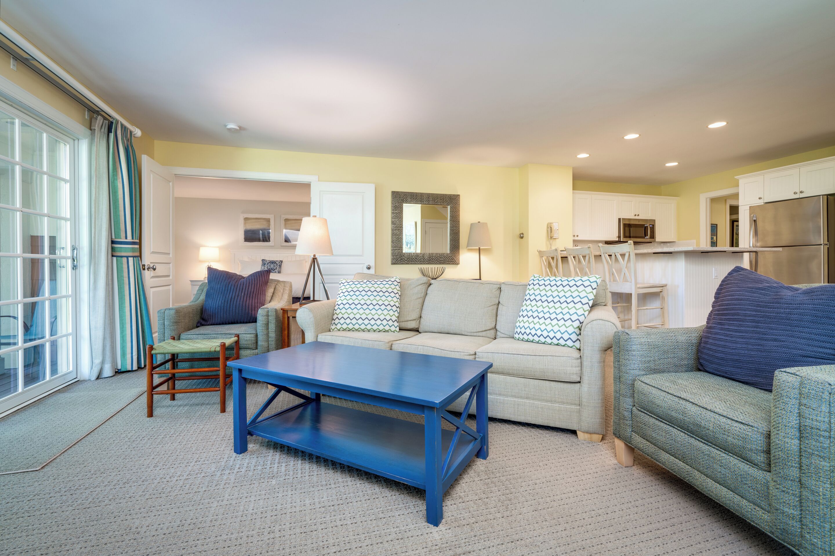 A living room with a sofa, a coffee table, and a dining area with chairs.