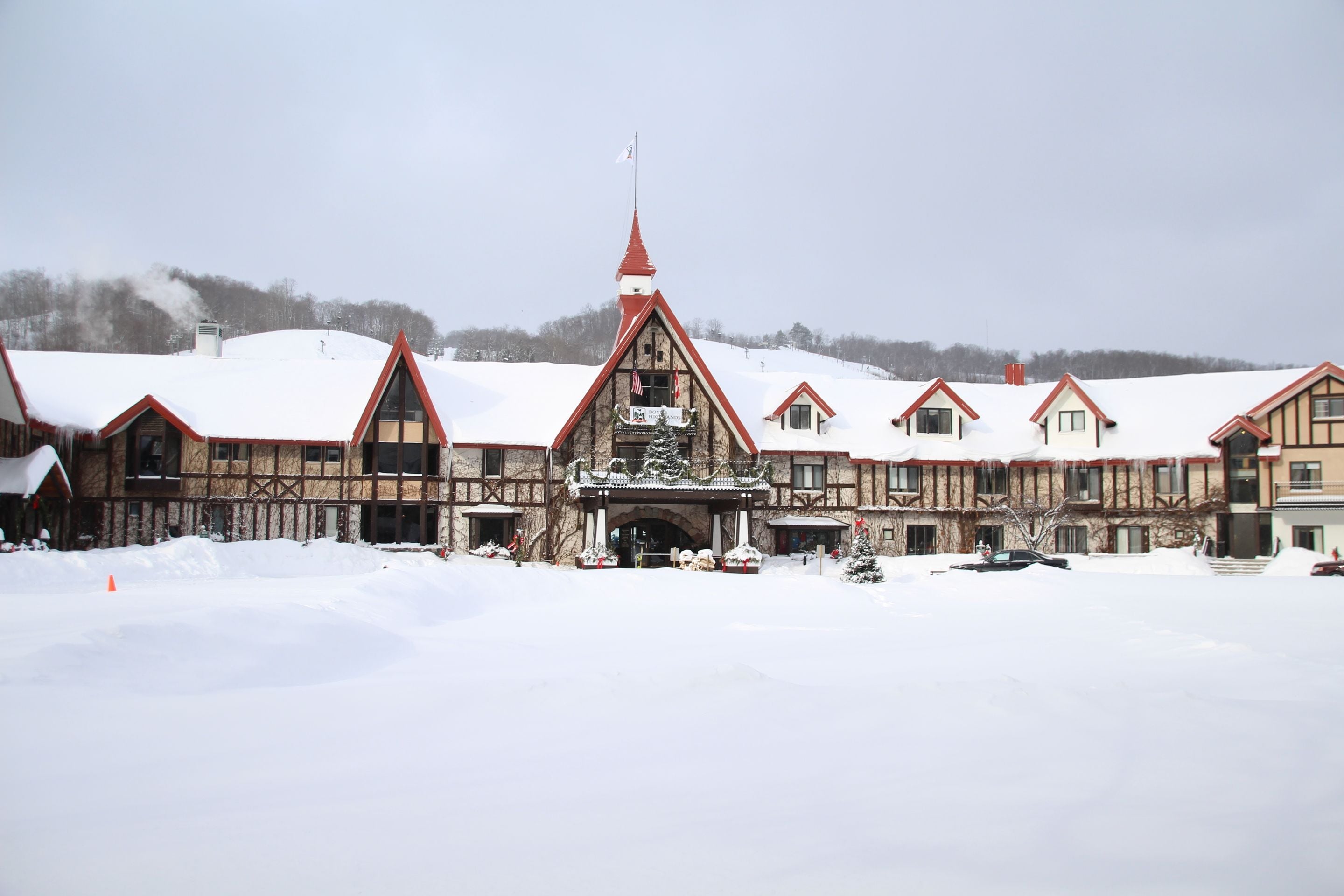 A historic building with a prominent tower and multiple gabled roofs, surrounded by a snowy landscape.