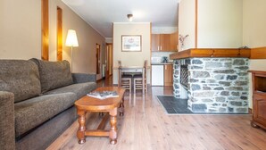 Un salón acogedor con sofá, una mesa de centro de madera y una chimenea de piedra.
