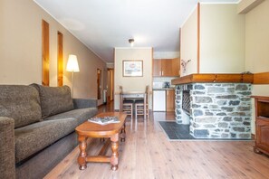 Un salon chaleureux avec un canapé, une table basse en bois et une cheminée en pierre.