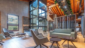 A modern interior with a wooden ceiling, large windows, and a green sofa. - Anyospark Hotel (Anyos)