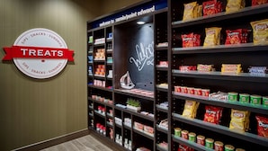 A wall with a sign reading "TREATS" and shelves stocked with snacks and drinks. - Hampton Inn by Hilton Sarnia/Point Edward (Sarnia)