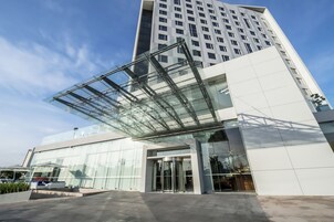 Een modern gebouw met een glazen ingang en een grote glazen luifel.