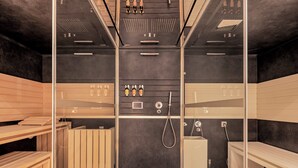 Een sauna met houten banken, een douchegedeelte in het midden en een bedieningspaneel aan de wand.