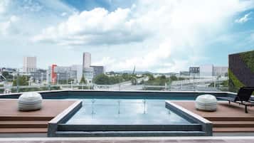 A rooftop pool with a city view, including a bridge and buildings.