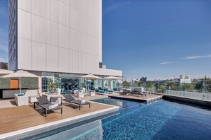 Alberca al aire libre, sombrillas en la alberca y camastros