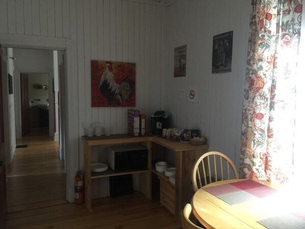 Una cocina con armarios de madera, una mesa de comedor y un cuadro en la pared.