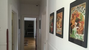 A hallway with framed posters on the wall and a wooden floor. - Hôtel du Chasseur (Brownsburg-Chatham)