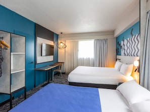 A hotel room with two beds, a desk, a TV, and a large window with curtains. - Ibis Styles Bordeaux Meriadeck (Bordeaux)