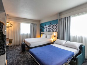 A hotel room with two beds, a desk, a chair, and a large window with curtains. - Ibis Styles Bordeaux Meriadeck (Bordeaux)