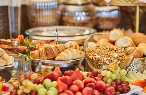 Buffet amb diversos aliments, com ara pastissos, fruita i granola.