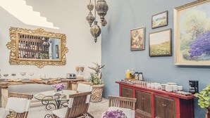 Un comedor con una mesa de vidrio, sillas de madera y un armario rojo.