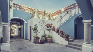 Un patio con escaleras, plantas en macetas y una decoración azul y blanca.