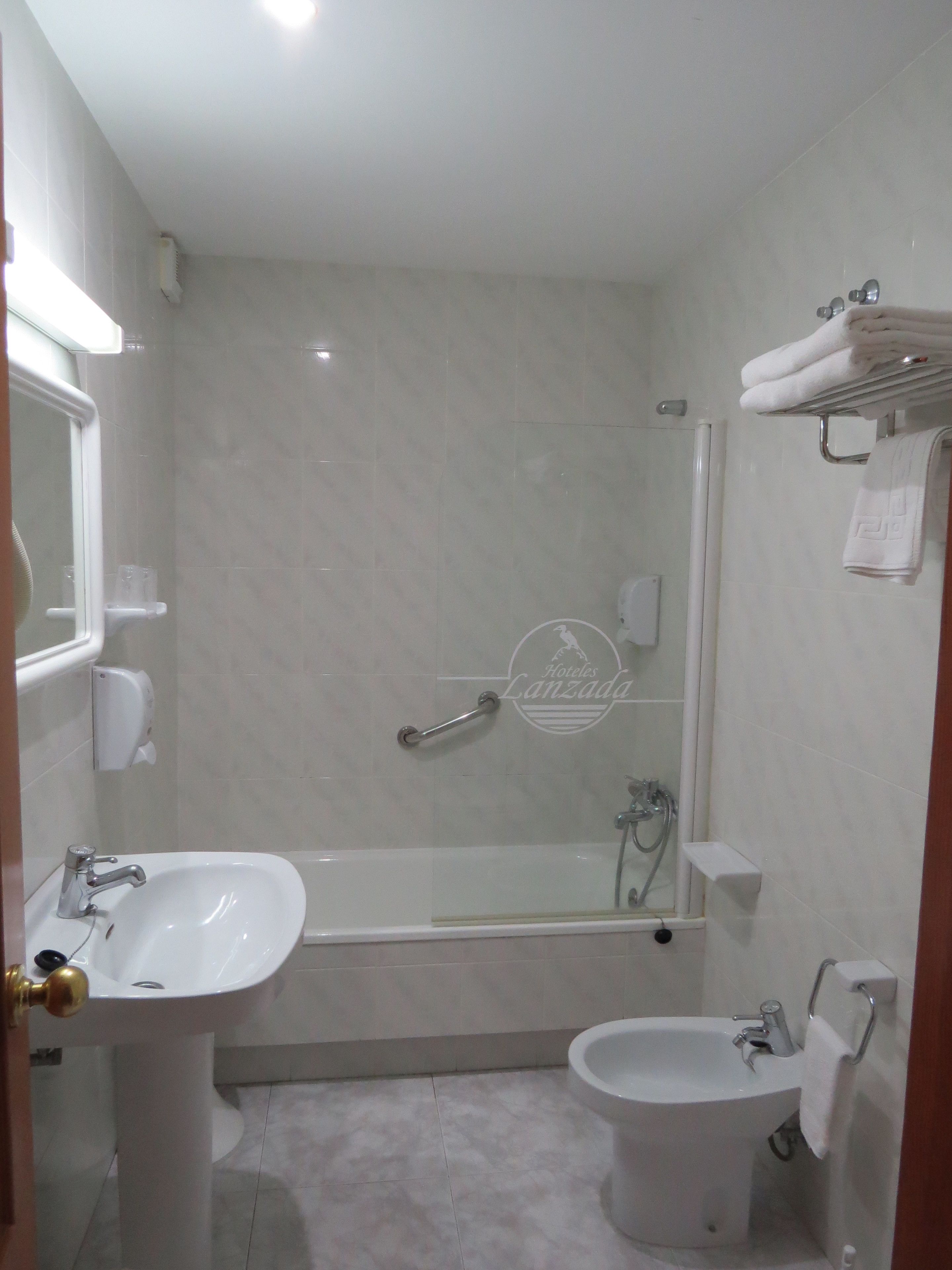 A modern bathroom with a bathtub, a sink, and a toilet.