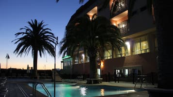 Una piscina al aire libre, tumbonas