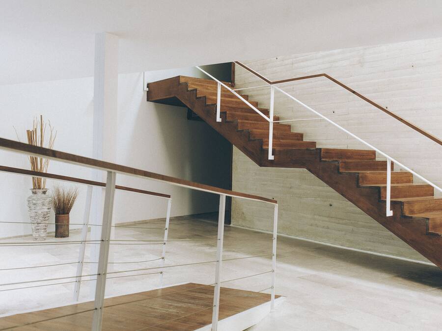 A modern staircase with wooden steps and white railings.
