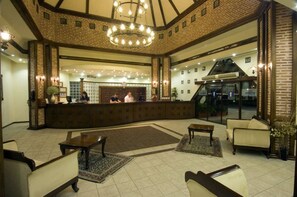 A spacious lobby with a reception desk, seating area, and a large chandelier. - Gypsophila Holiday Village (Alanya)