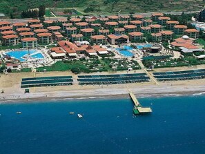 An aerial view of a resort with multiple buildings, a beach, and a pier. - Gypsophila Holiday Village (Alanya)