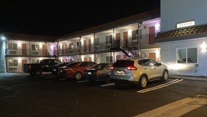 A motel with multiple floors, a parking lot, and a sign indicating an office.