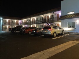 Un motel de varios pisos, con estacionamiento y un letrero que indica la oficina.