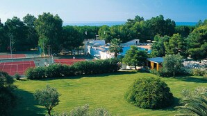 A coastal property with a tennis court, a swimming pool, and a small building with a blue roof. - Villaggio Triton - Aurum Hotels (Sellia Marina)