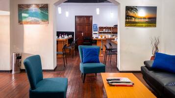 Uma sala de estar aconchegante com piso de madeira, um sofá, uma mesa de centro e uma área de jantar com cadeiras e mesa.