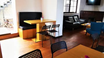 A modern living room with a sofa, a coffee table, and a TV mounted on the wall.