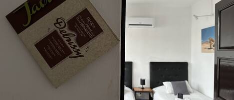 Ein Zimmer mit zwei Betten, einem Nachttisch und einem Wandbild.