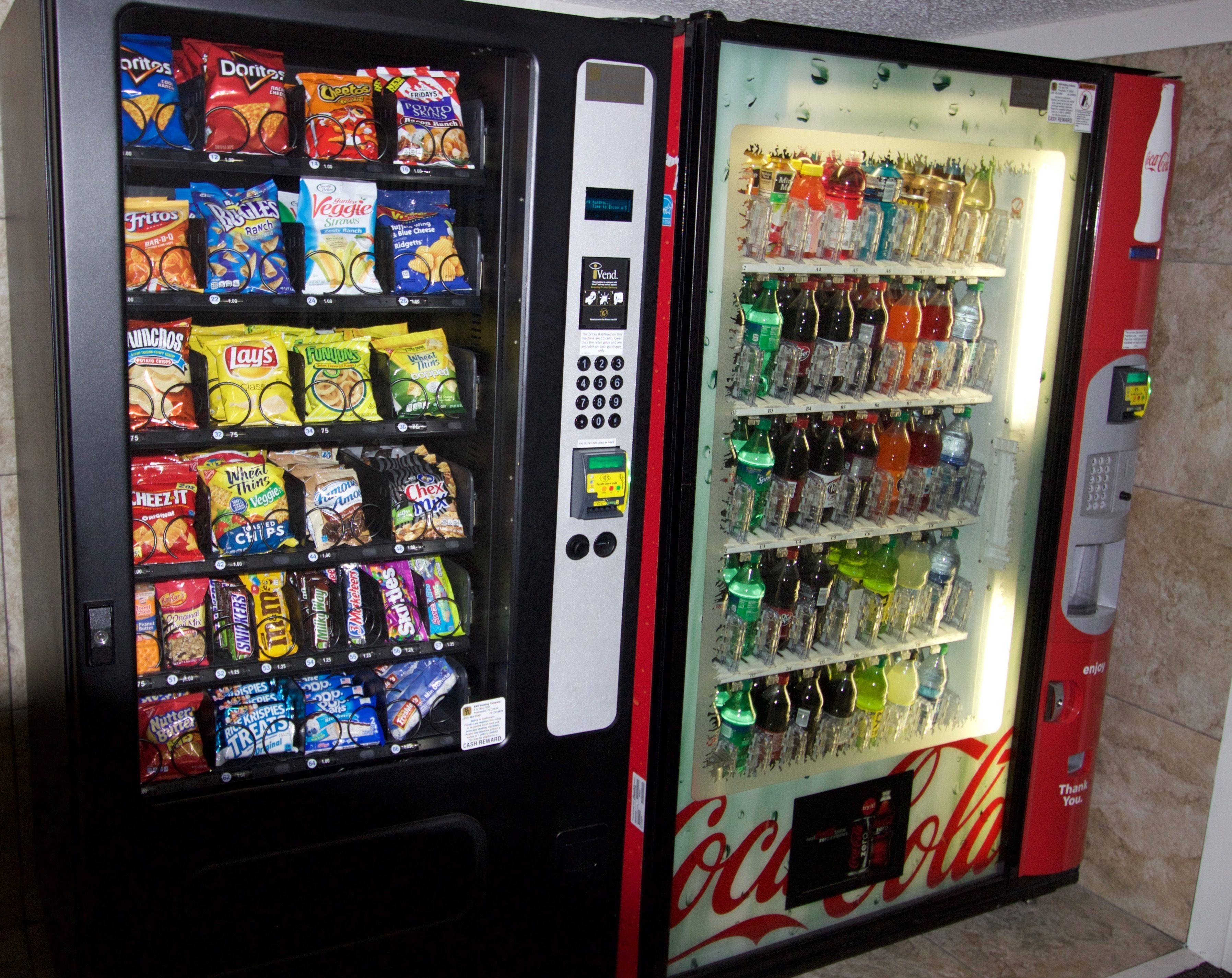 A vending machine with snacks and Coca-Cola bottles.