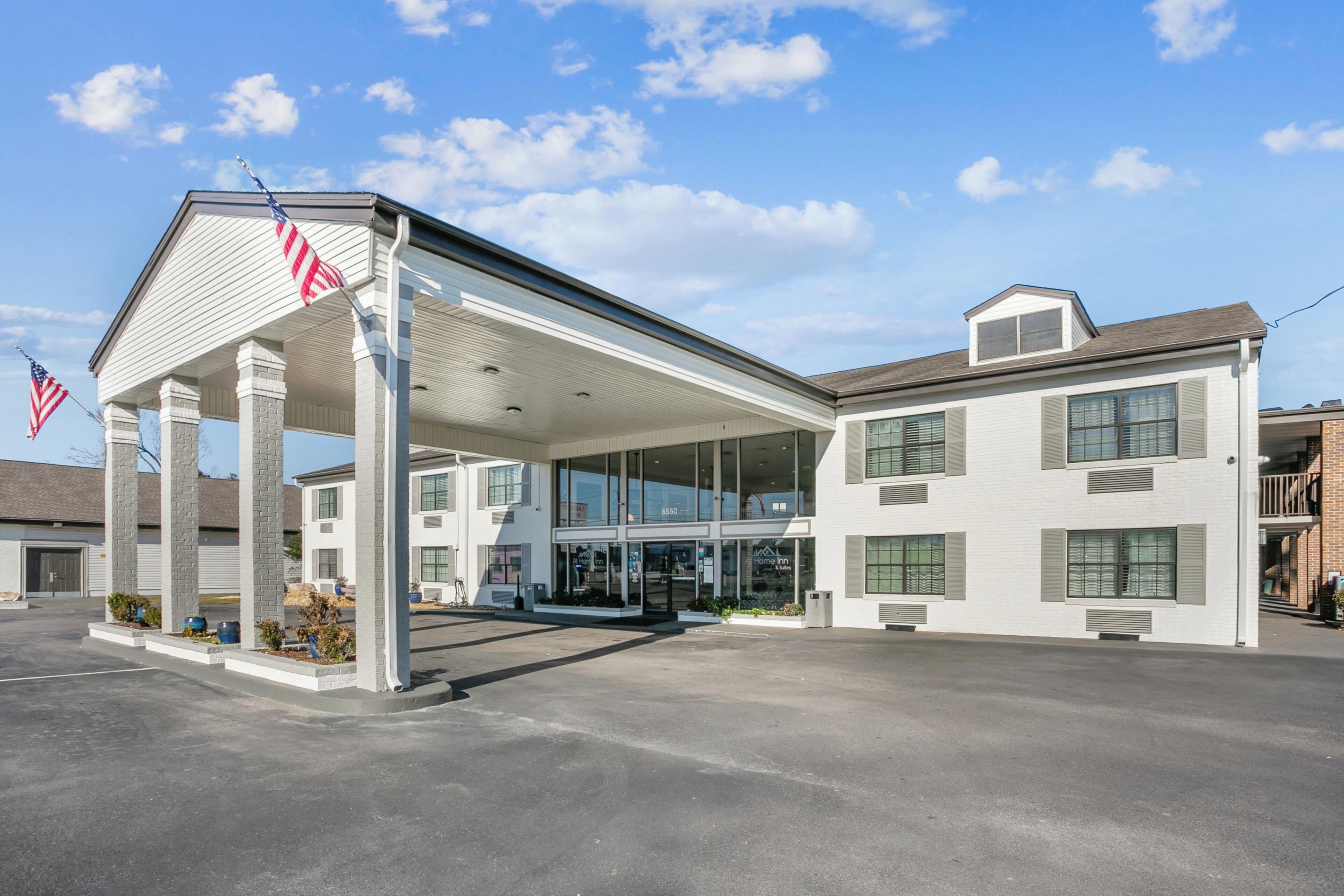 A gas station with a covered area, multiple windows, and an American flag.