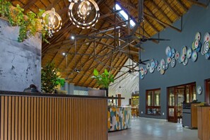 A spacious lobby with a high ceiling, wooden beams, and a reception desk. - Hippo Hollow Country Estate (Mbombela)