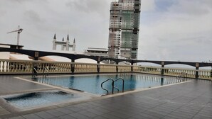A rooftop swimming pool with a view of a tall building under construction. - Hotel Grand Continental Kuala Terengganu (Kuala Terengganu)