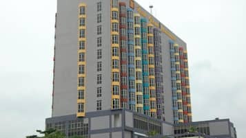 A multi-story hotel with a modern architectural design, featuring a prominent entrance and a series of balconies.