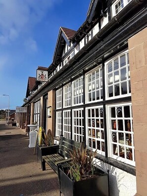 A traditional building with multiple windows and a sign indicating food is served daily. - Panmure Arms (Brechin)