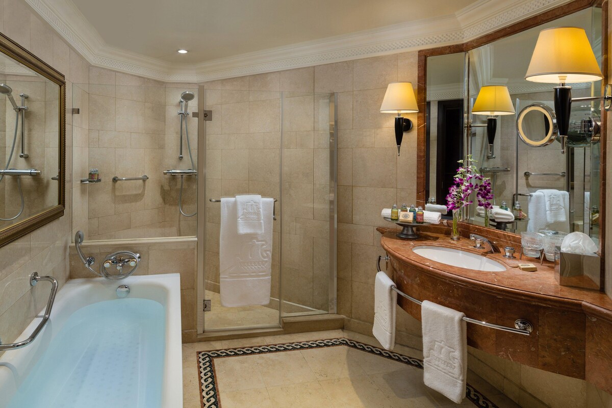 A modern bathroom with a bathtub, shower, and vanity.