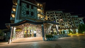 A hotel with a modern design, featuring a prominent entrance with steps and a glass facade.