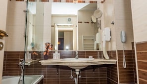 A bathroom with a glass shower enclosure, a sink with a mirror, and a telephone. - Rhodopi Home (Chepelare)