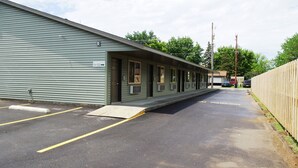 A motel with a row of rooms, a parking area, and a wooden fence. - Eden Valley Motel (Eden Valley)
