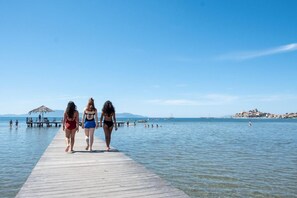 A wooden pier extending into calm waters with a clear sky. - Gitavillage Talamone (Orbetello)