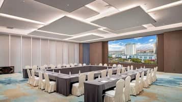 A conference room with a long table, chairs, and a city view.