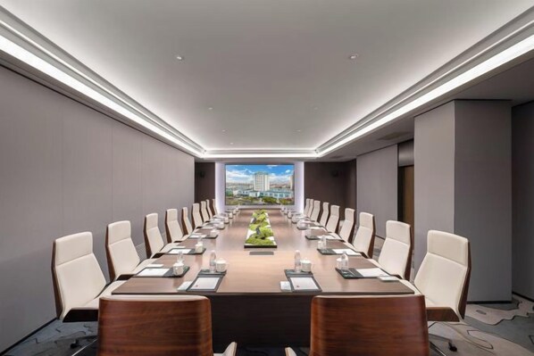 Une salle de conférence avec une longue table, des chaises et une vue sur la ville.