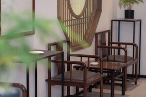 Una habitación con una silla de madera y una pequeña mesa.