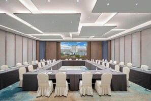 Une salle de conférence avec une longue table, des chaises et une vue sur la ville.