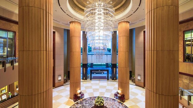 A spacious lobby with high wooden columns, a large chandelier, and a checkered floor. - Shantou Junhua Haiyi Hotel (Shantou)