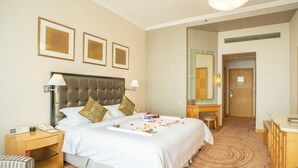 A hotel room with a large bed, bedside tables, a desk, and a mirror. - Shantou Junhua Haiyi Hotel (Shantou)