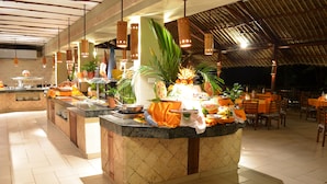 A buffet area with a central island, multiple serving stations, and a variety of food items. - Baobab Beach Resort (Diani Beach)