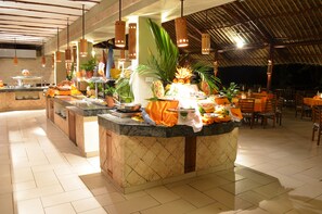 A buffet area with a central island, multiple serving stations, and a variety of food items. - Baobab Beach Resort (Diani Beach)
