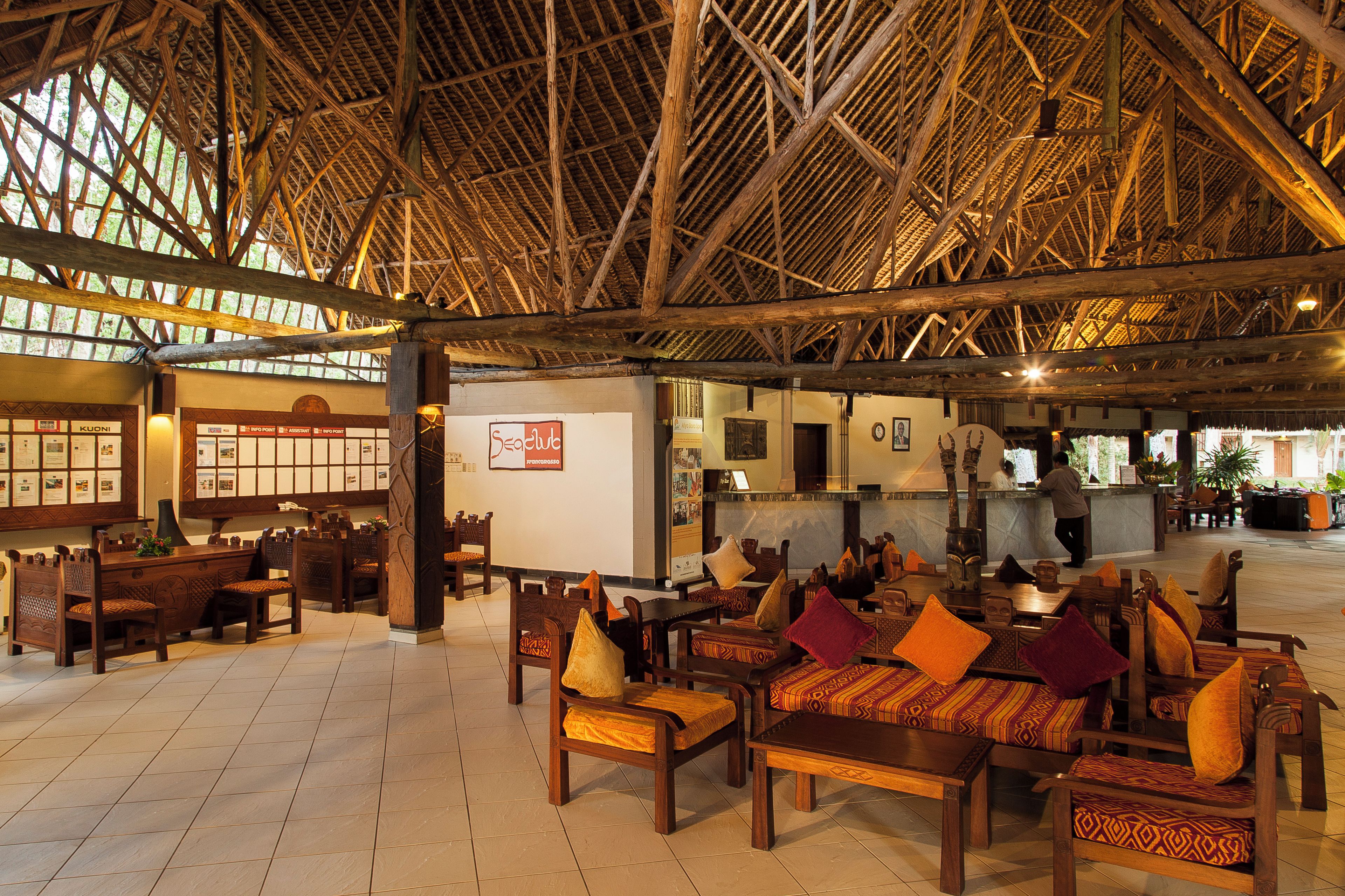 A spacious lobby with wooden furniture and a high ceiling.