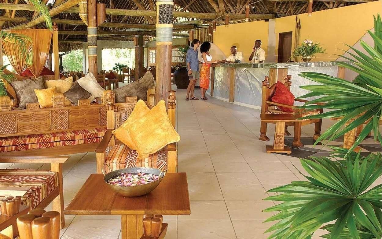 A reception area with a wooden reception desk, seating arrangements, and a large plant.