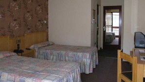 A hotel room with two beds, a wooden headboard, a desk, and a chair. - Bonavida (Canillo)